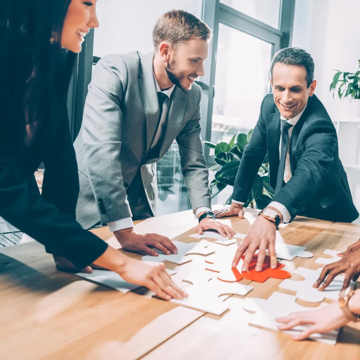 A premium group of business people working together to elevate their problem-solving skills through a challenging puzzle.