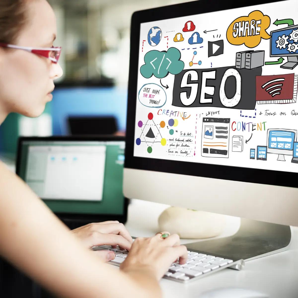 A woman working on a computer with premium SEO displayed on the screen.