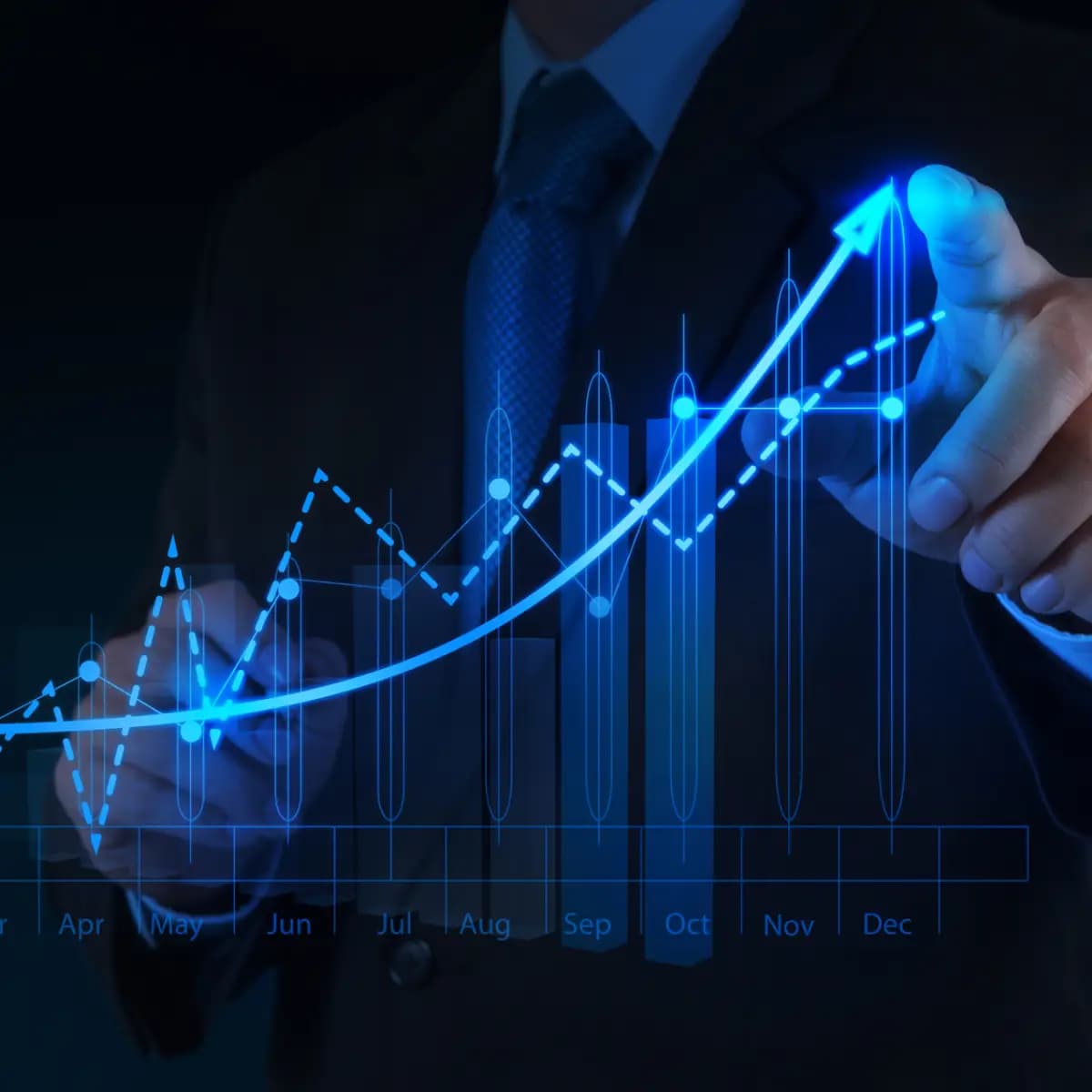 A premium businessman is pointing at a graph with an upwards arrow.